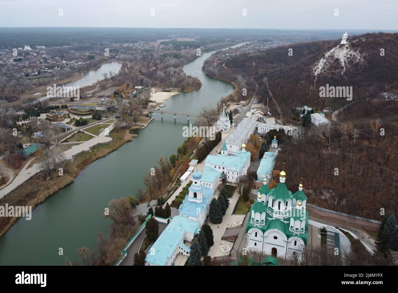 Panoramic aerial drone view of Svyatohirsk Lavra, Seversky Donets river with bridge, and village of Svyatohirsk, Donetsk region, Ukraine. Stock Photo