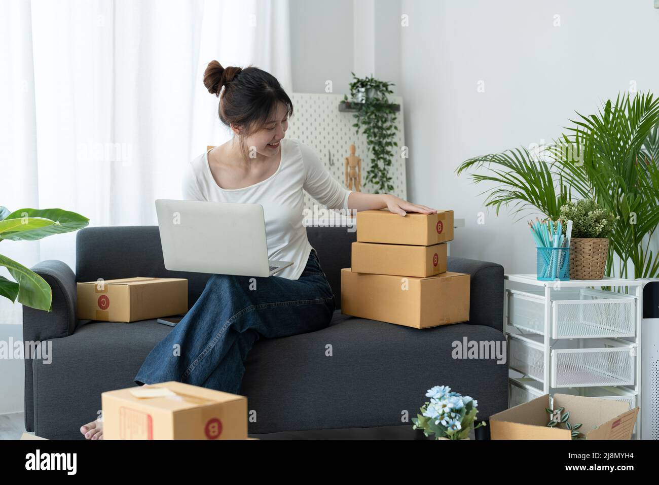 Starting Small business entrepreneur SME freelance, Portrait young woman working at home office, box,,laptop, online, marketing, packaging, delivery Stock Photo