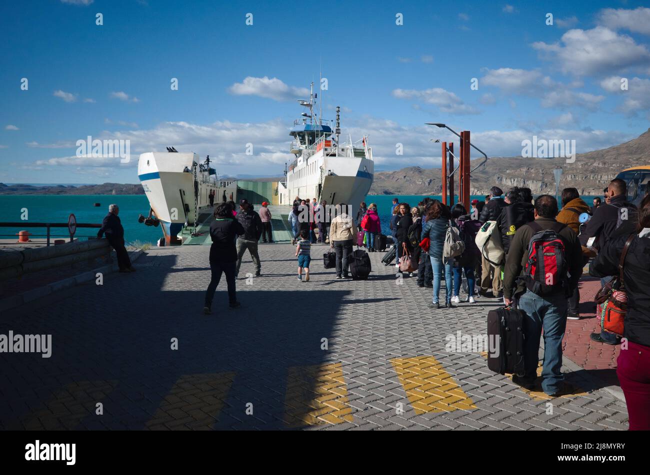 Puerto Ibanez, Chile - March, 2020: Boarding queue to ferry from Puerto Ibanez to Chile Chico on General Carrera lake. Passengers  with suitcases wait Stock Photo