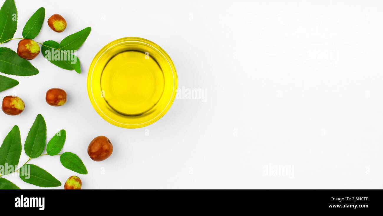 Fresh ripe jojoba fruit and jojoba oil in a bowl on a white background, copy space Stock Photo