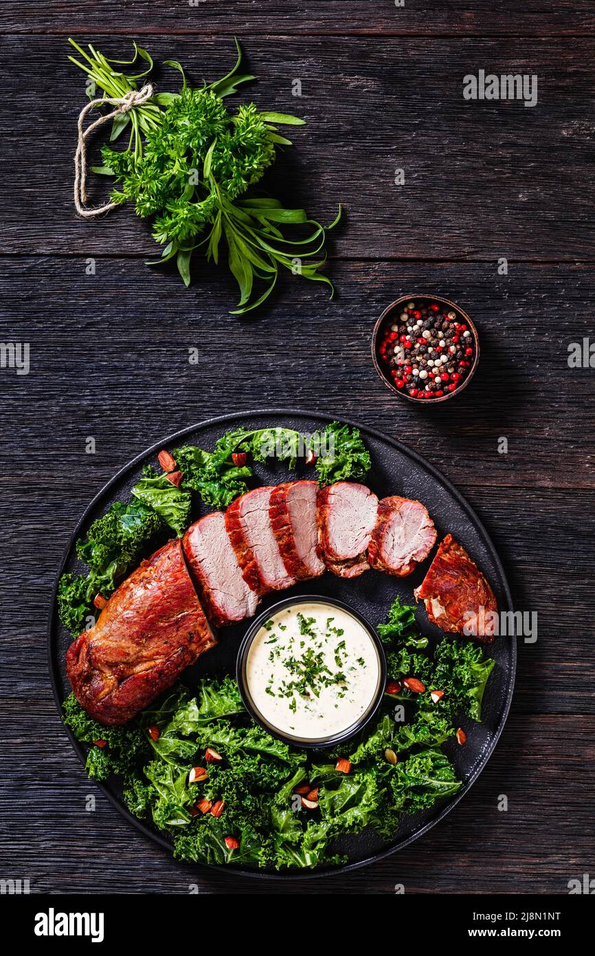 Roast Pork Tenderloin with Creamy Mustard Tarragon Sauce on black plate