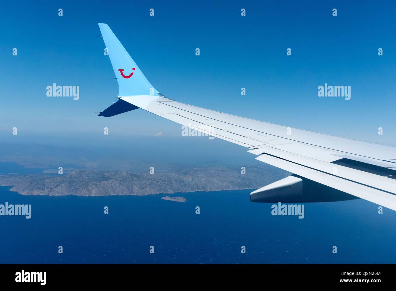 A TUI aircraft wing shown in flight with a passenger view from the planes cabin. The TUI company logo is clearly shown on the wings wing tip winglet Stock Photo