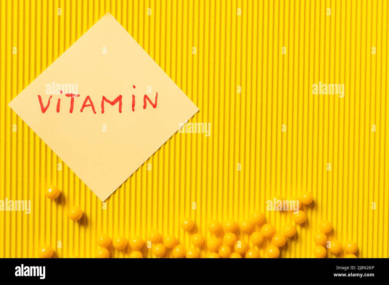 Vitamin Lettering top view of round shape medication near paper note with vitamin ...