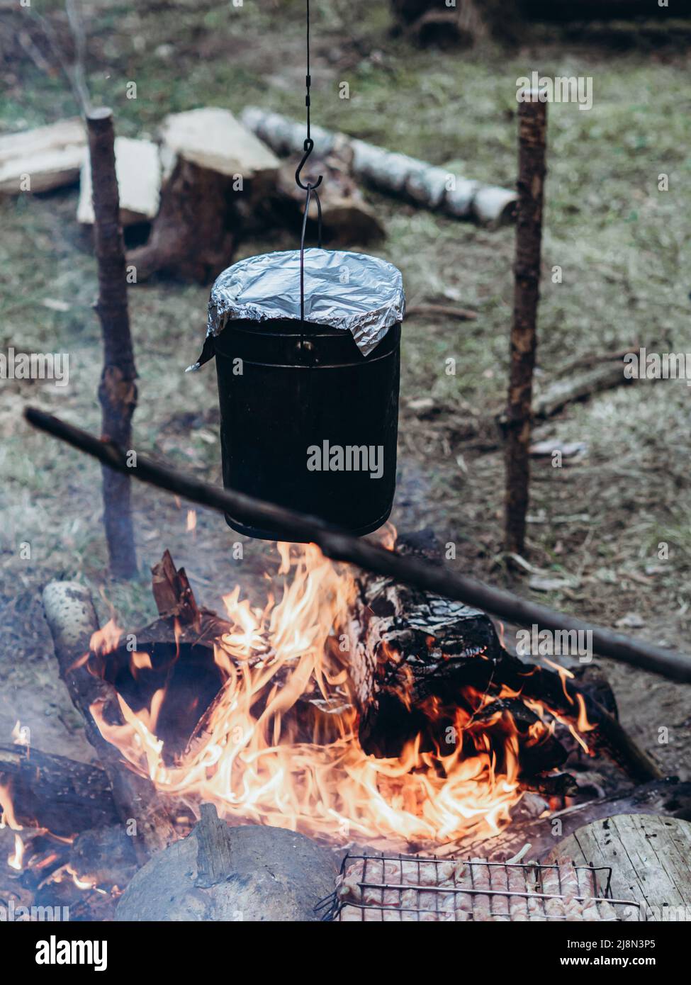 https://c8.alamy.com/comp/2J8N3P5/the-kettle-hangs-over-the-fire-cooking-at-the-campsite-camping-detail-travel-lifestyle-photo-2J8N3P5.jpg