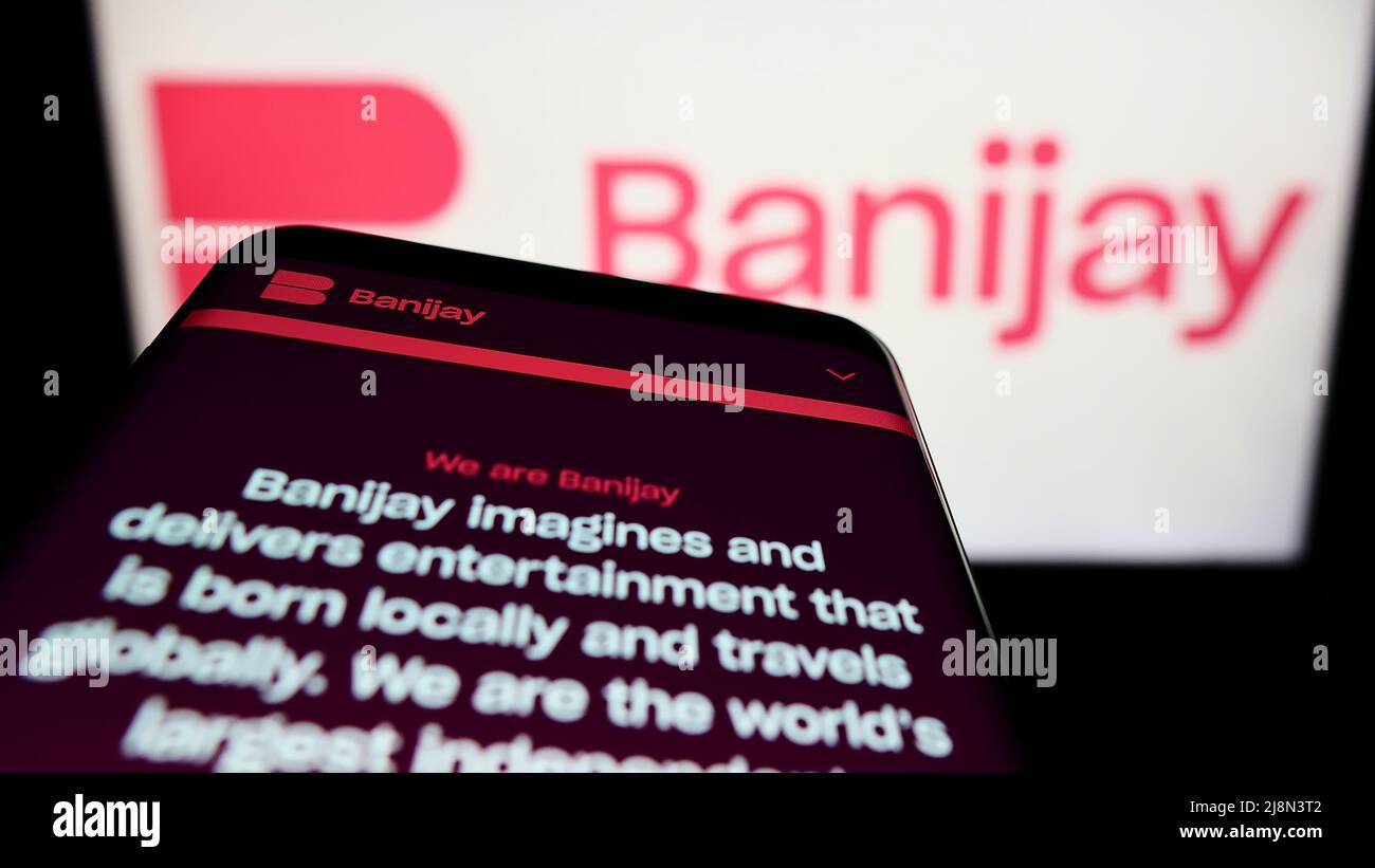 Mobile phone with website of French entertainment company Banijay Group on screen in front of business logo. Focus on top-left of phone display. Stock Photo