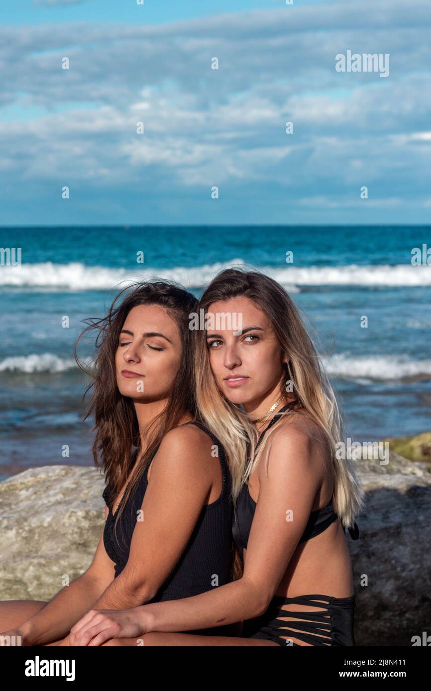 lesbian beach Two lesbian women hugging each other on the beach as they pose in bikinis  between rocks and the ocean in the background Stock Photo - Alamy