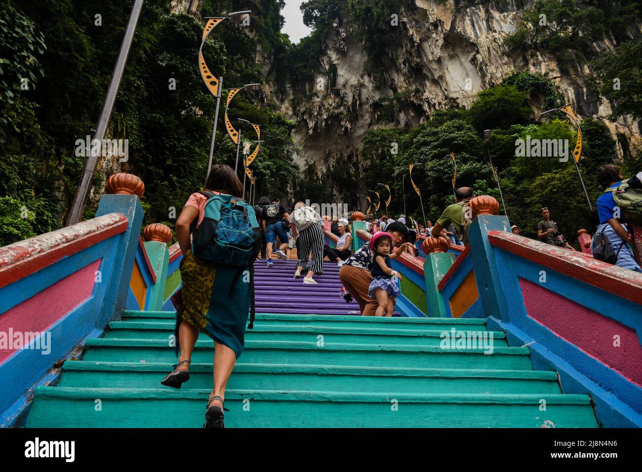 A tourist girl climbing the steep steps in front od Batu caves Stock Photo