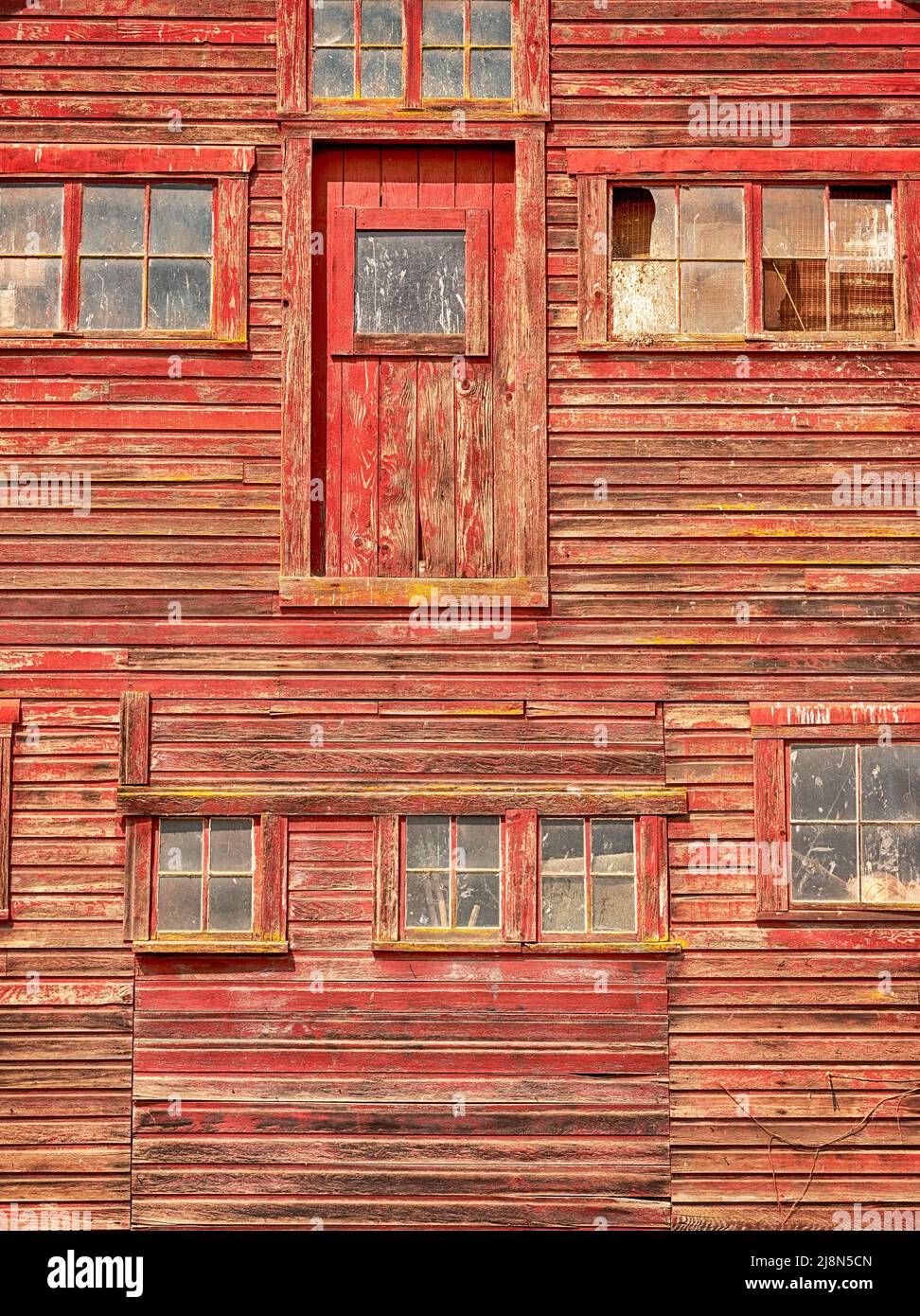 The exterior wall of a barn in Oregon appears to have a patchwork of doors and windows. Stock Photo
