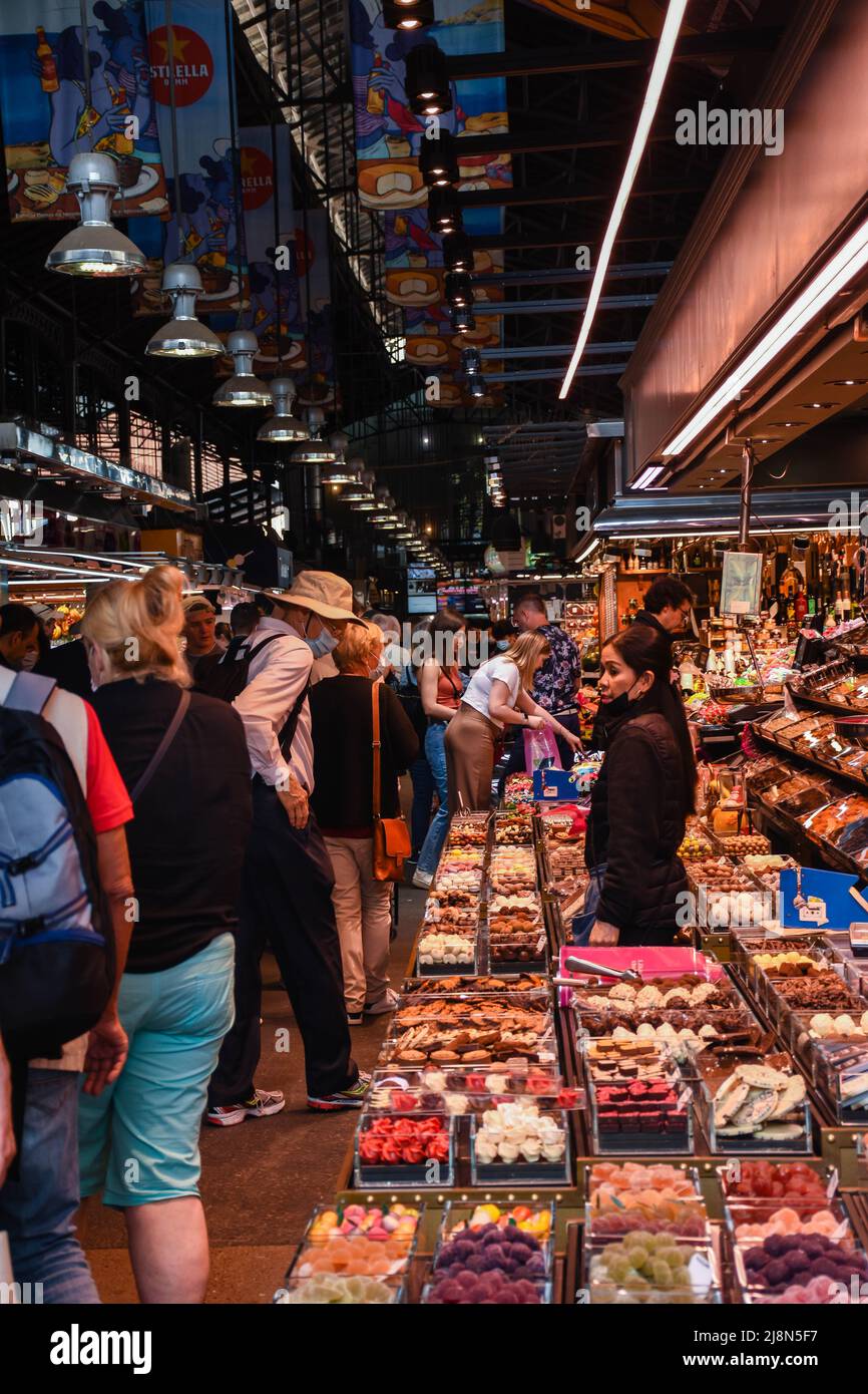 A group of people looking ad food stalls in a spanish market. Stock Photo