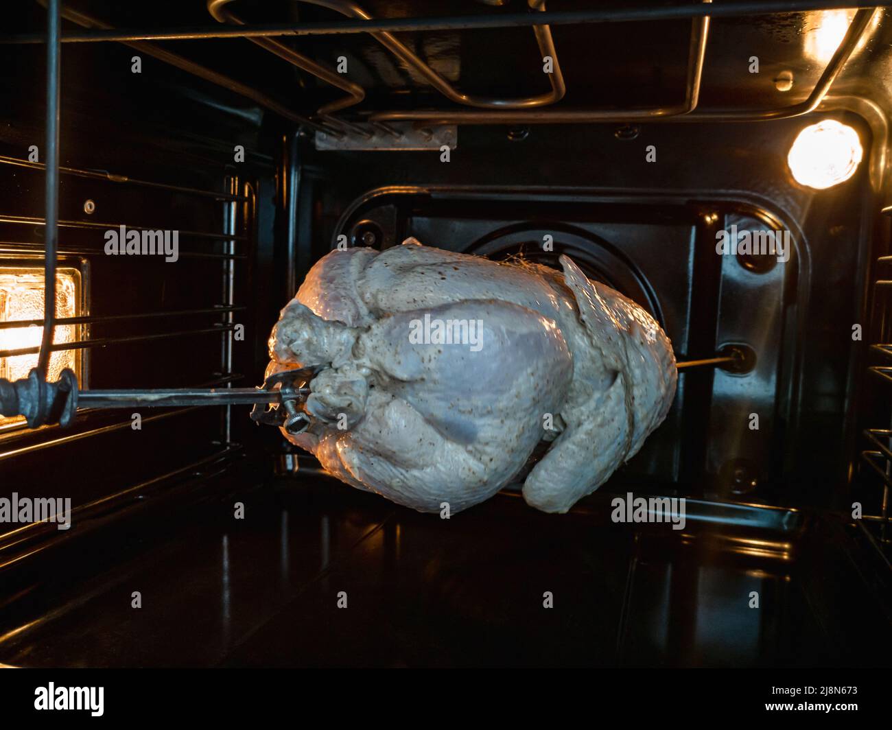 Cooking grilled chicken on a spit in an electric oven Stock Photo Alamy
