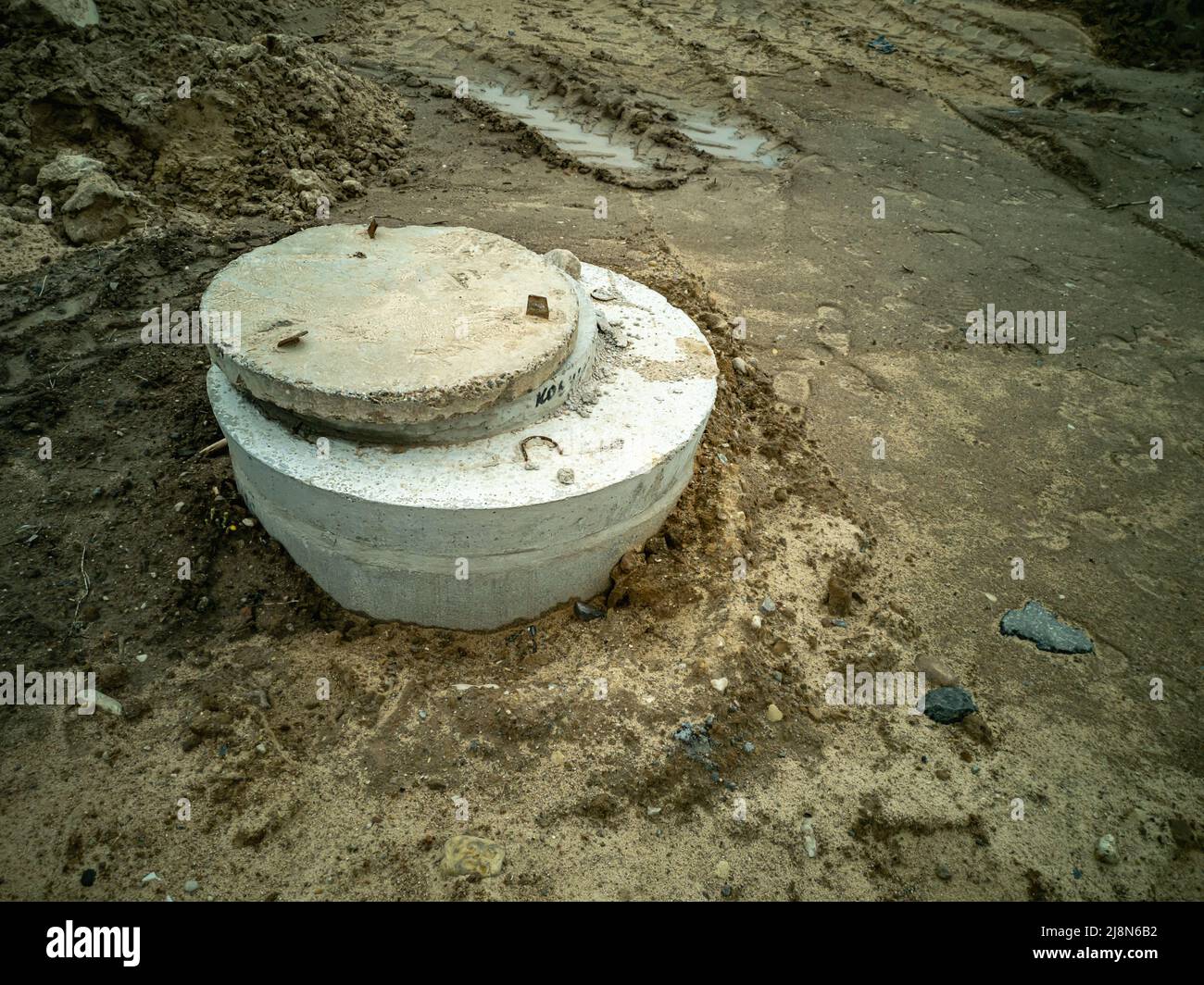 Dugin concrete well rings with a concrete cover. Plumbing and sewerage
