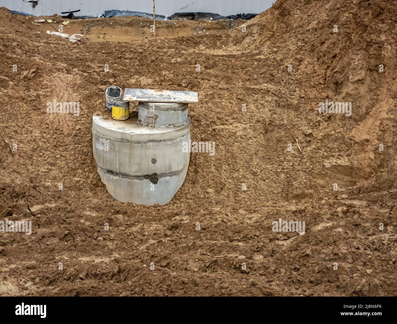 Dugin concrete well rings with a concrete cover. Plumbing and sewerage