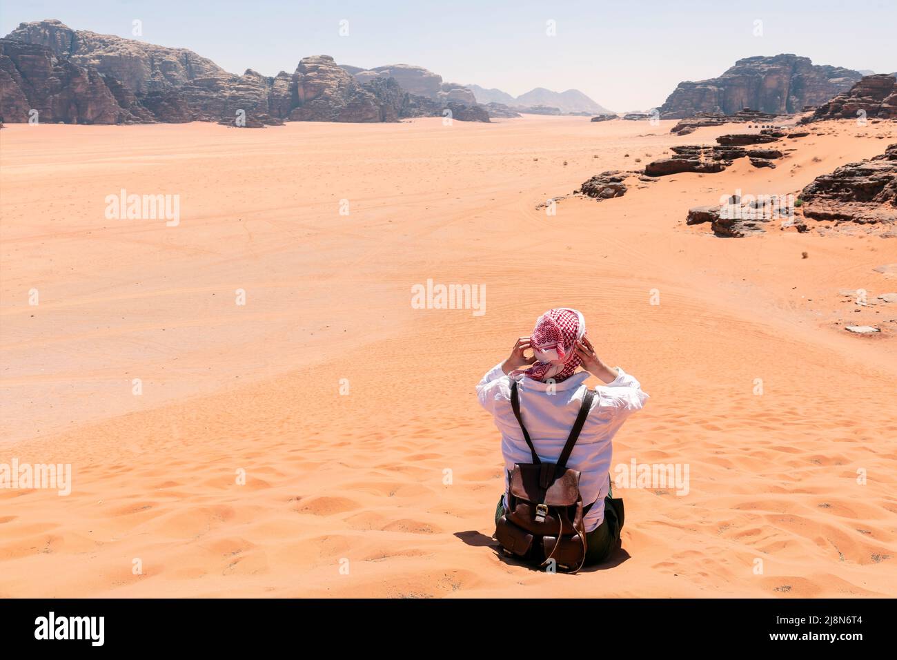 A tourist standing by the look out of a panoramic view of the desert in Wadi Rum, Jordan, Middle East. Stock Photo
