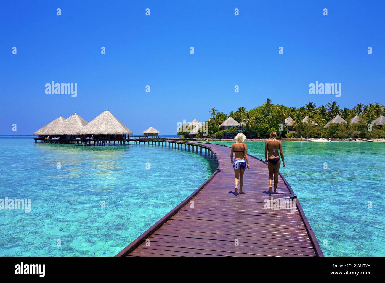 Two girls on the jetty at luxury water bungalows, Rannalhi, Maldives South-Male Atoll, Indian Ocean, Asia Stock Photo