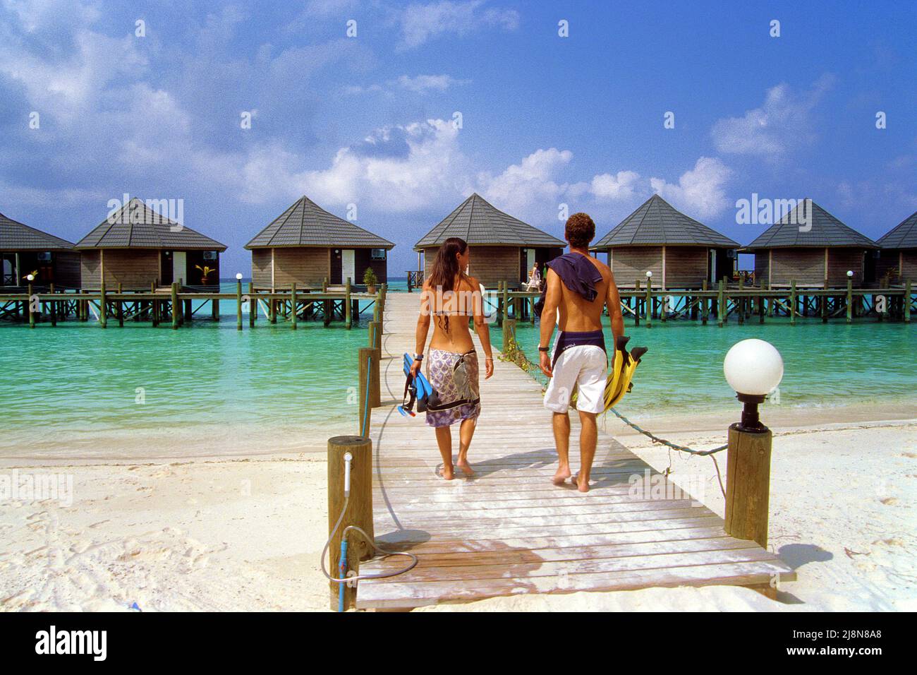 Couple on the jetty at luxury water bungalows, Kuredu, Laviyani Atoll, Indian Ocean, Asia Stock Photo