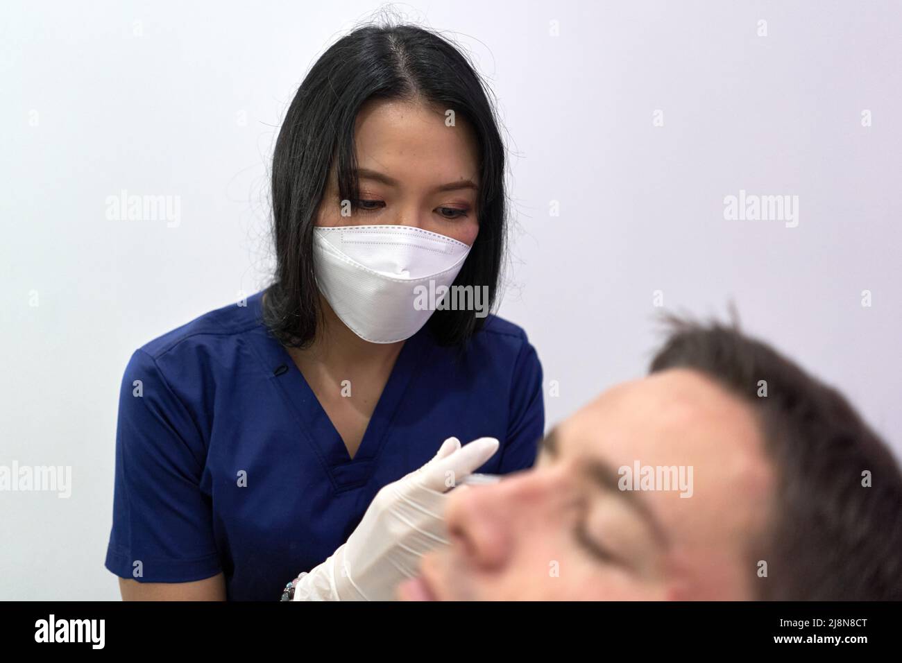 Focus on a doctor injecting botox into a patient in a clinic Stock Photo