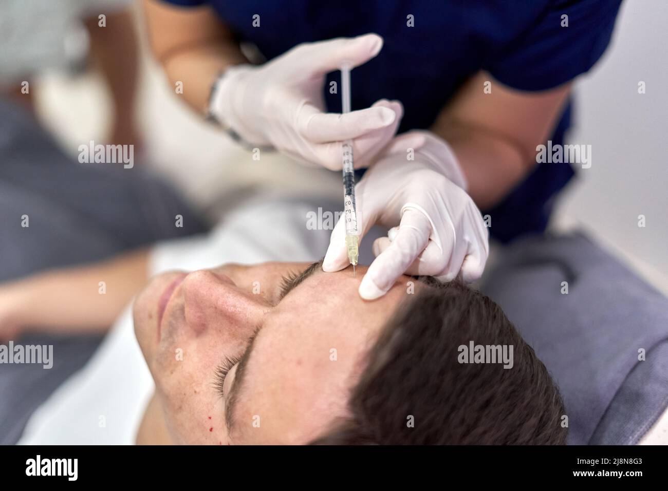Patient getting a shot of botox in the forehead Stock Photo
