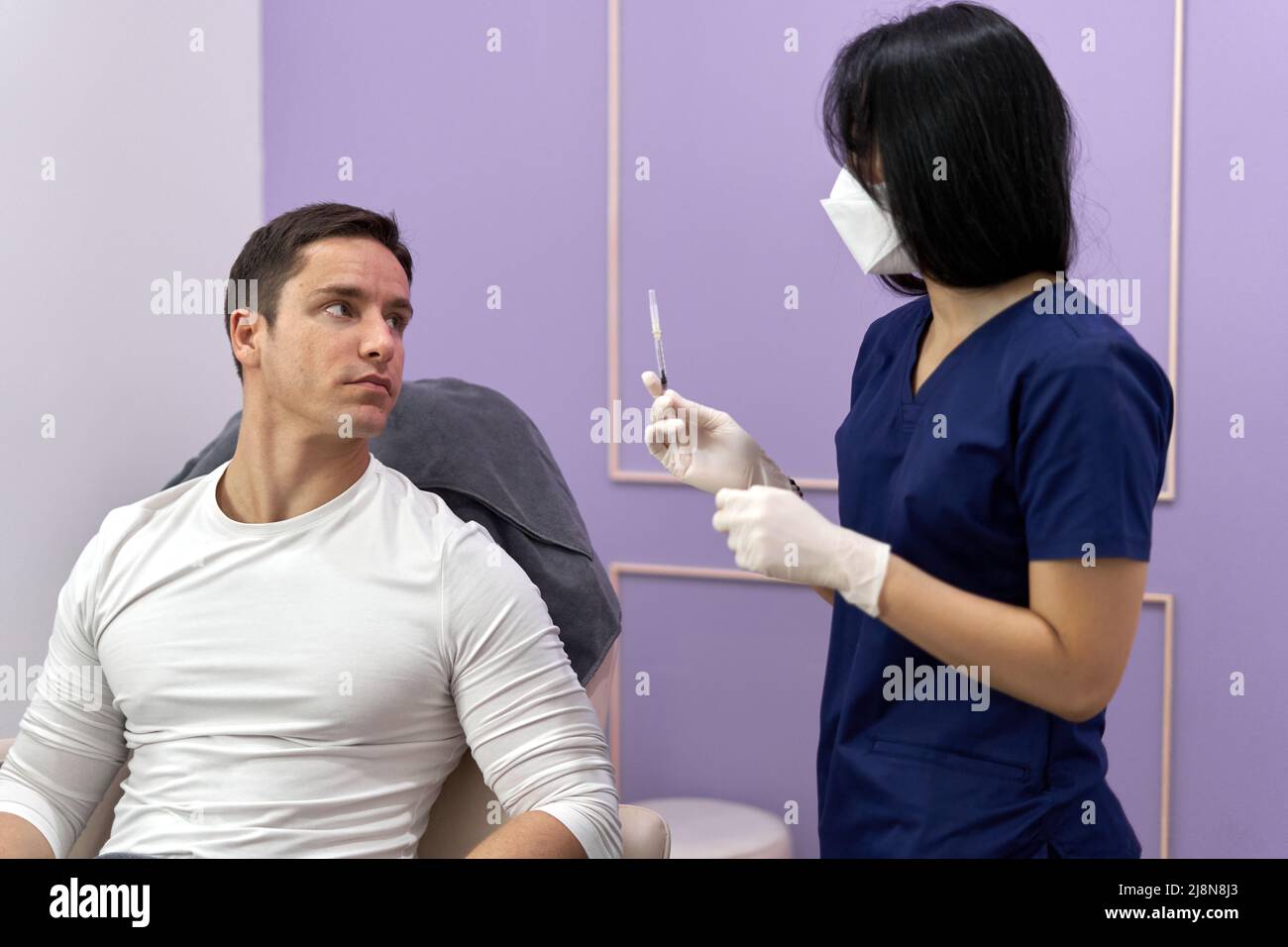 Patient and doctor talking before start a botox treatment to rejuvenate the skin Stock Photo