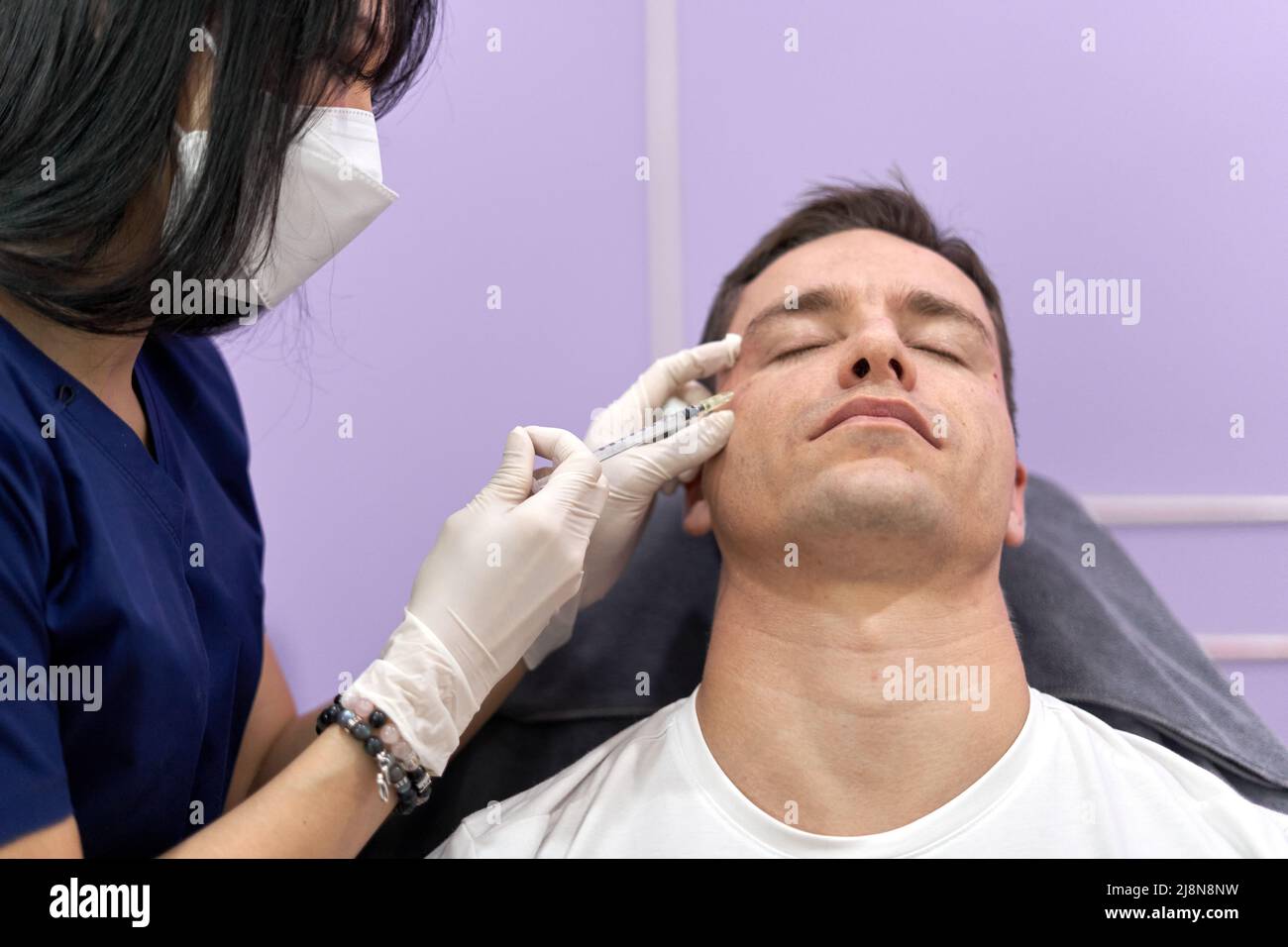 Man receiving forehead botox injection for facial rejuvenation ...
