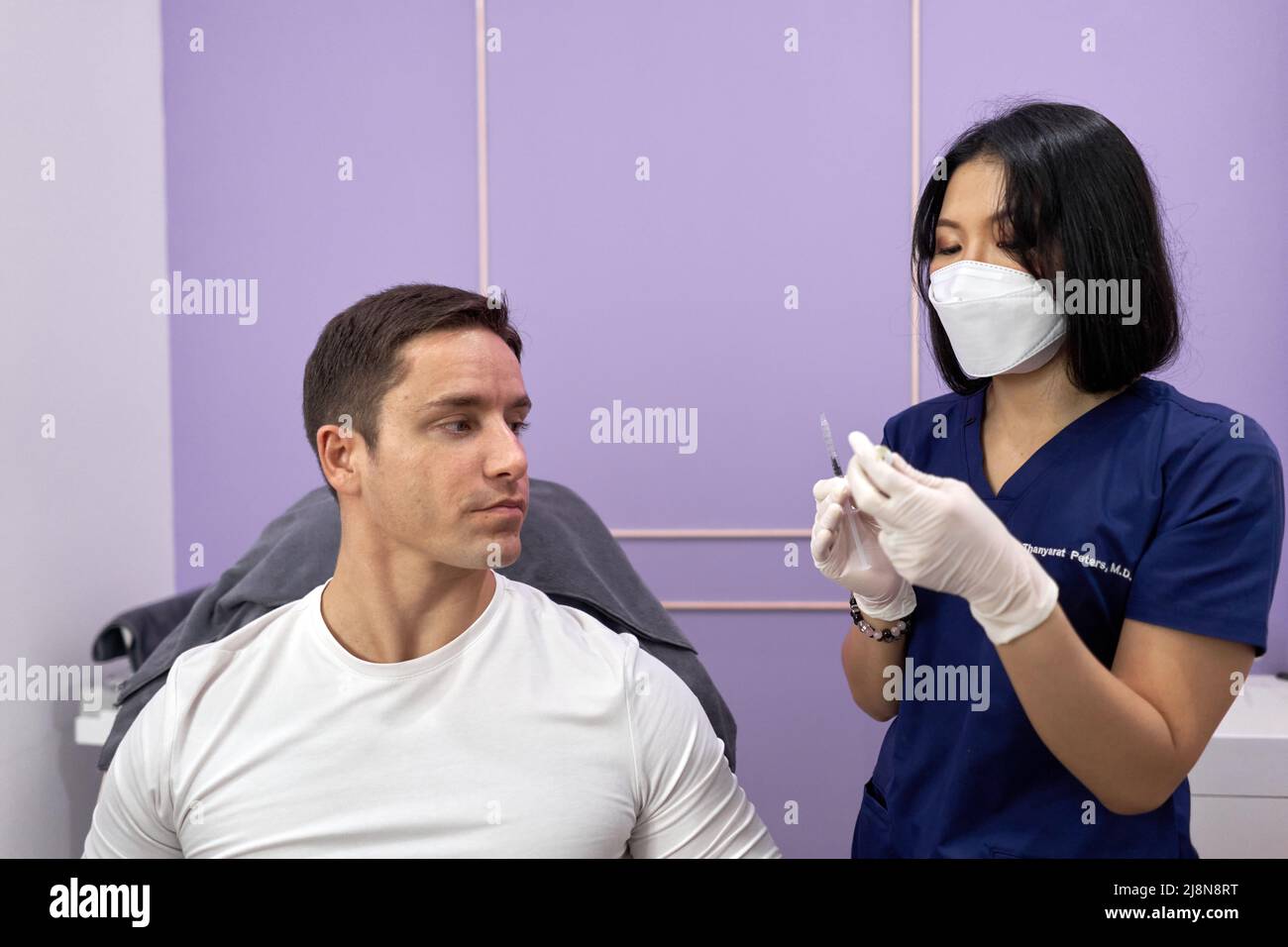 Doctor preparing the injection she will use on a patient for a beauty treatment. Stock Photo