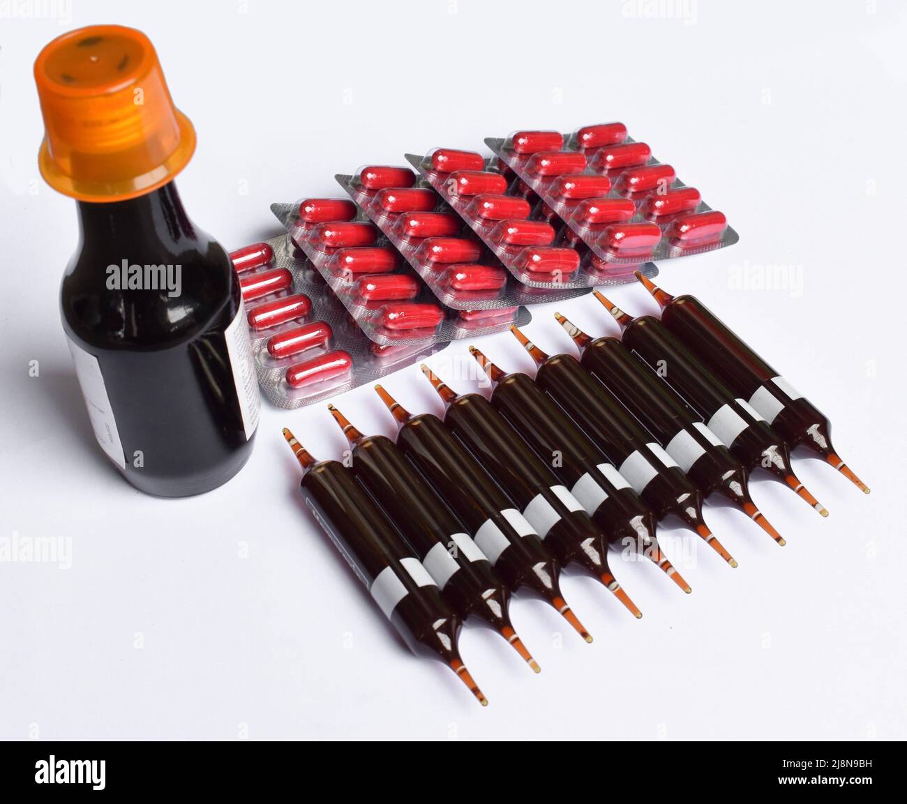 Glass ampoules, bottle and  capsules containing iron supplement solution to treat anaemia. Stock Photo