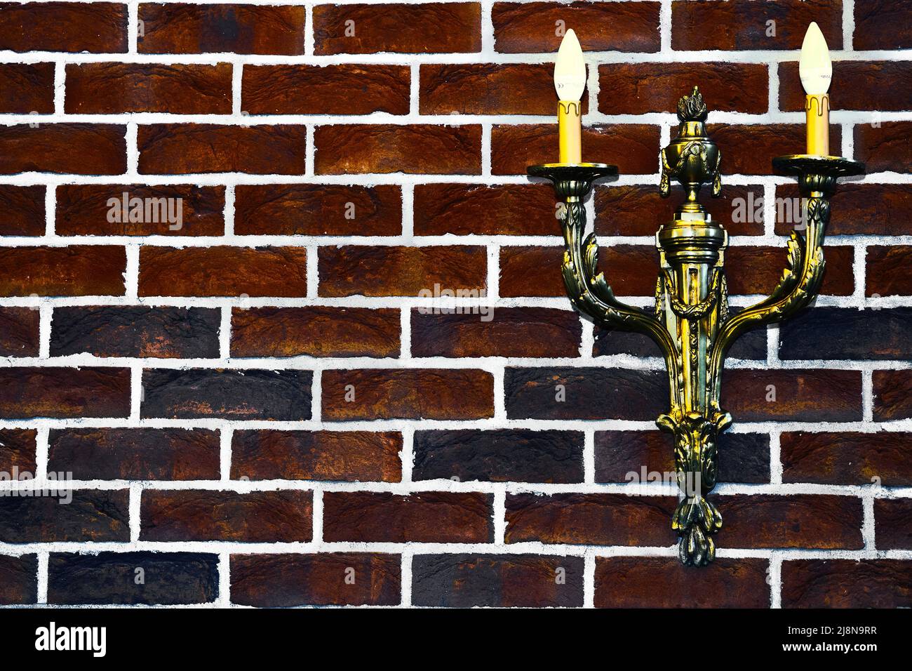 Double gold candlestick lamp on red black brick wall Stock Photo Alamy