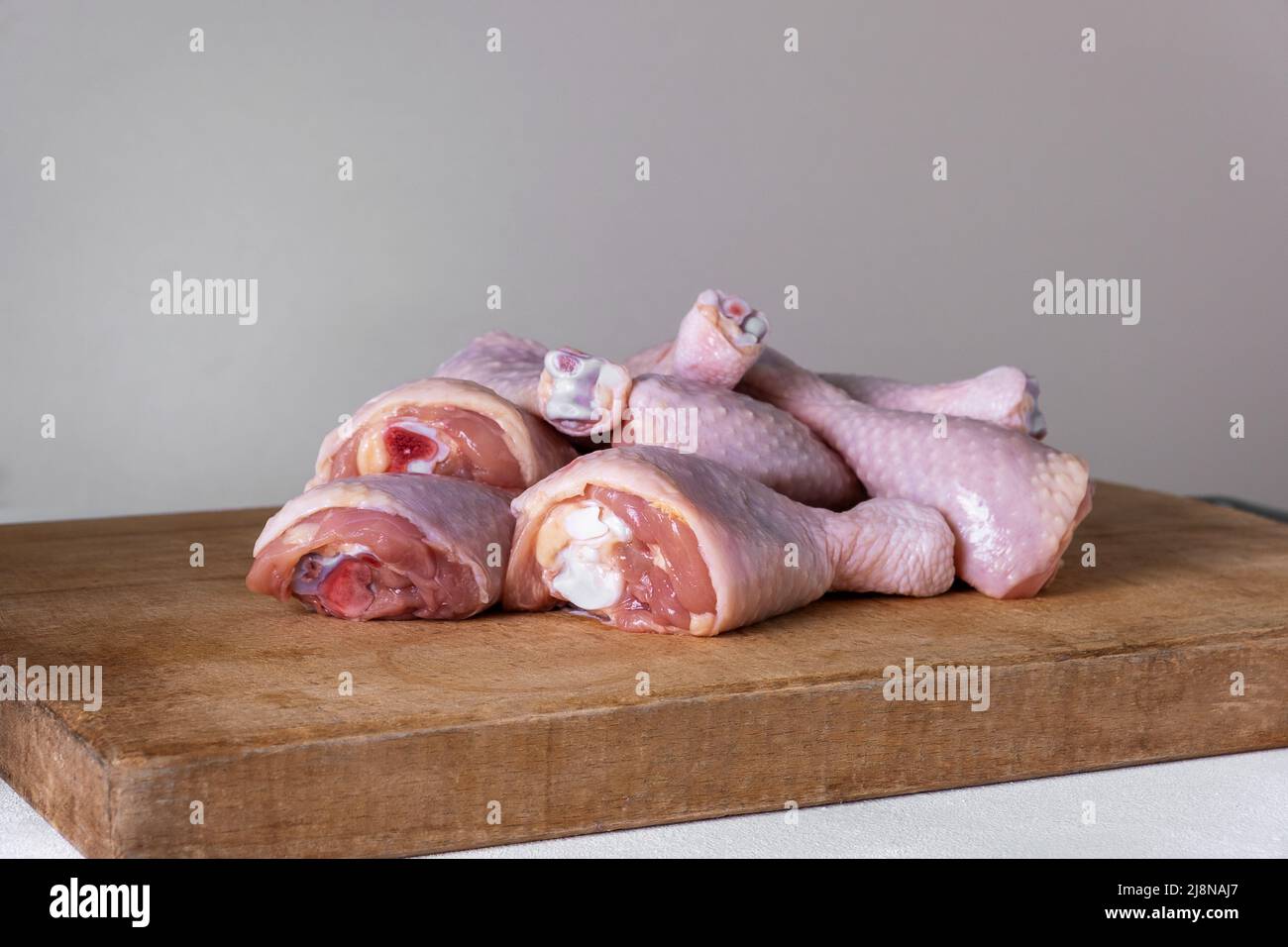 fresh uncooked chicken drumsticks laid out in a heap Stock Photo