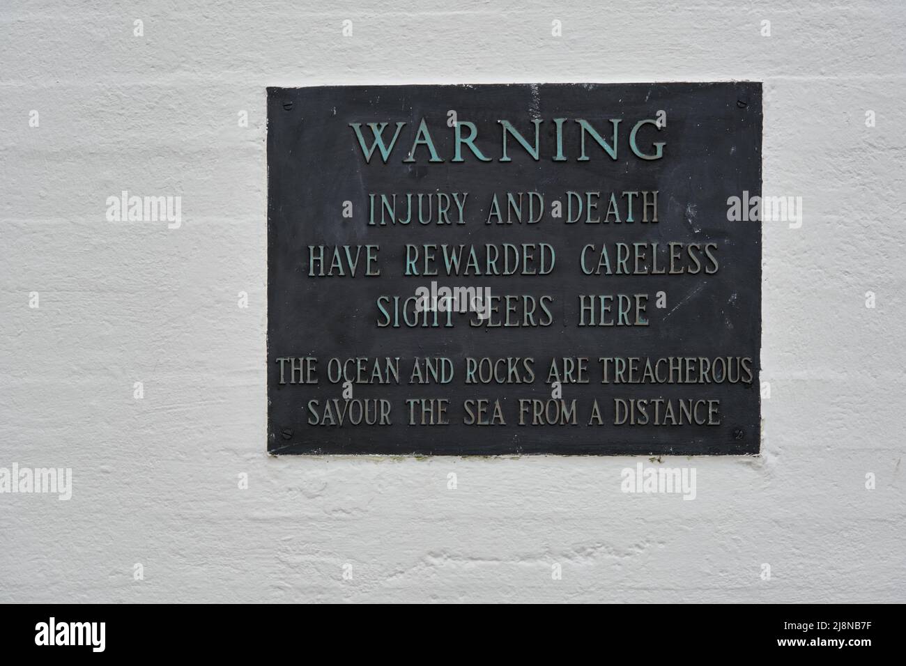 Warning sign about danger of ocean and slippery rocks at Peggy's Cove
