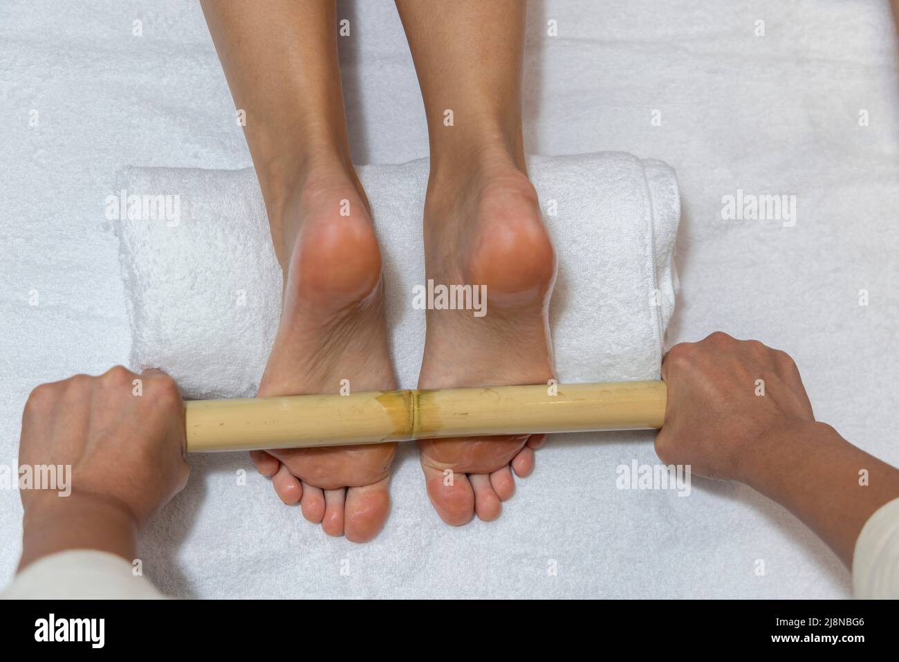 Woman getting a bamboo feet massage. Stock Photo