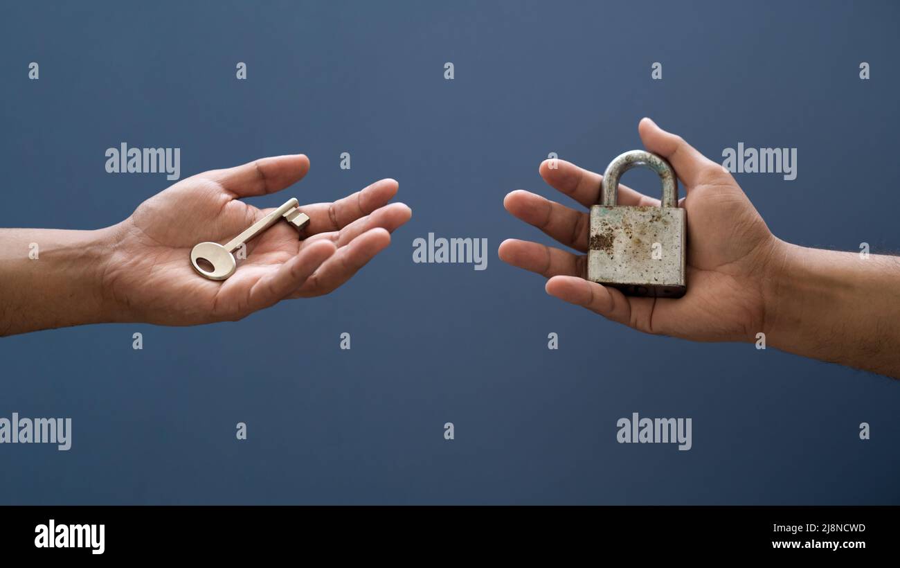 Hands holding lock and key on isolated background. Concept of solving problem and solution Stock