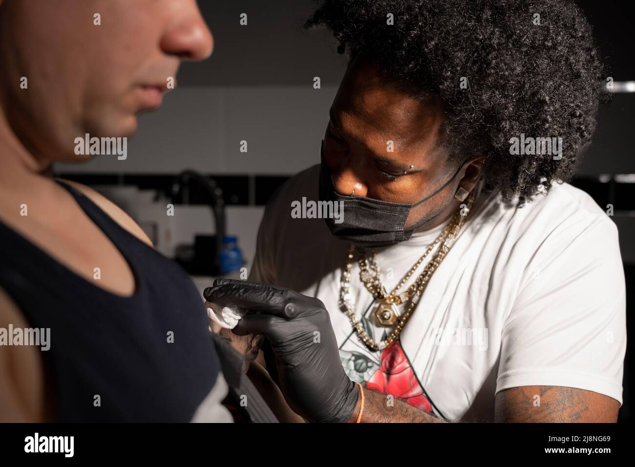 Professional African American tattoo artist makes a tattoo on client