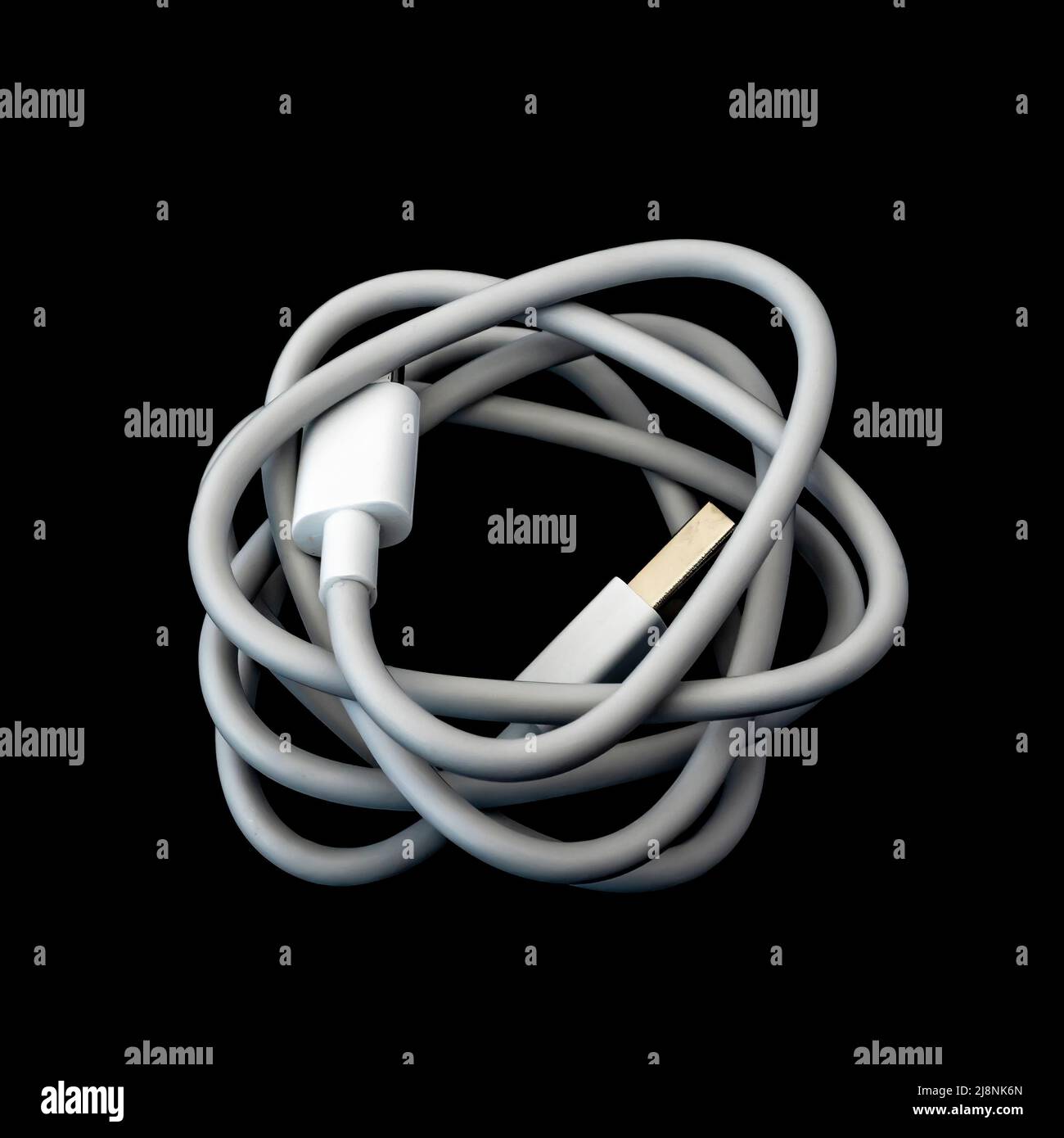 A white usb type c cable isolated against a black background. Stock Photo