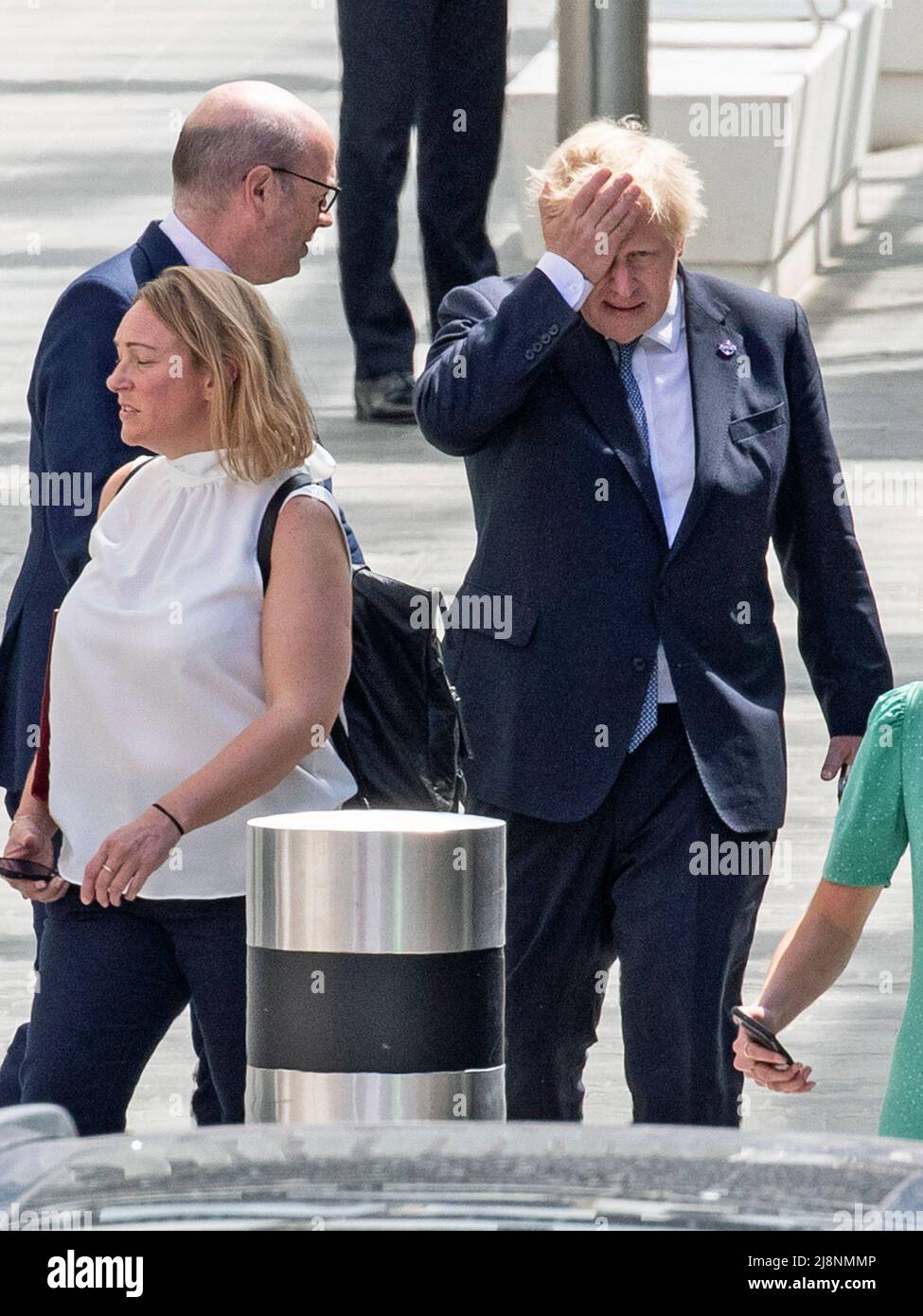 London - 17/05/2022. Prime Minister Boris Johnson is seen with his hand on his head as he leaves the opening of the new Elizabeth Line that was attended by Her Majesty Queen Elizabeth, at Paddington Station, West London. Mr Johnson and the Government are under pressure to resolve the Northern Ireland Protocol issues. Credit: Alamy Live News/Joshua Bratt Stock Photo