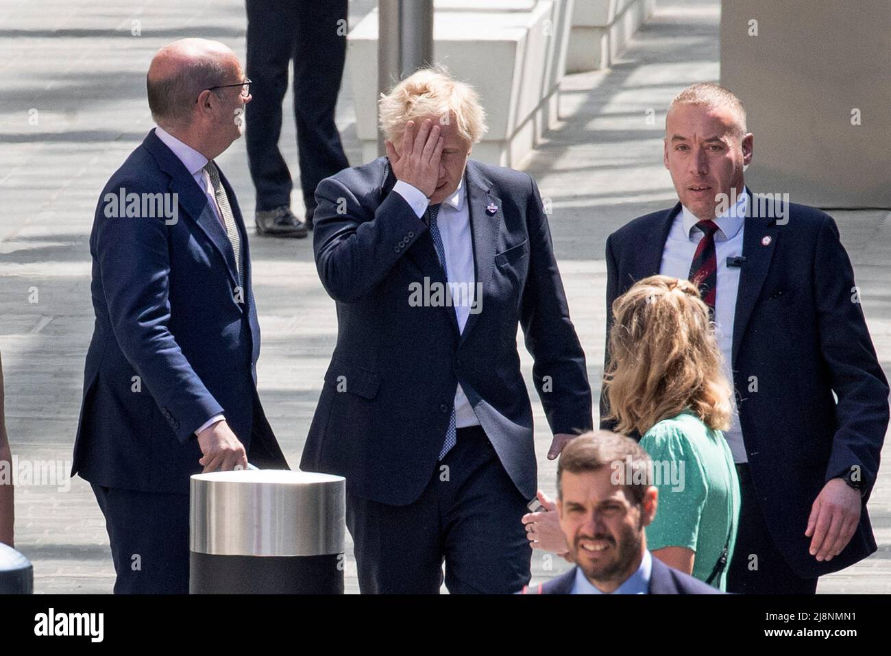 London - 17/05/2022. Prime Minister Boris Johnson is seen with his hand on his head as he leaves the opening of the new Elizabeth Line that was attended by Her Majesty Queen Elizabeth, at Paddington Station, West London. Mr Johnson and the Government are under pressure to resolve the Northern Ireland Protocol issues. Credit: Alamy Live News/Joshua Bratt Stock Photo