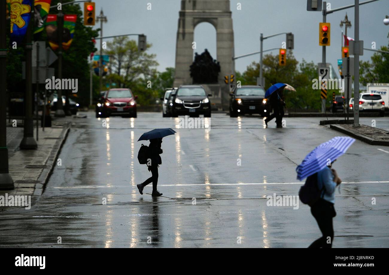 People cross Elgin Street as rain falls in Ottawa, on Tuesday, May 17