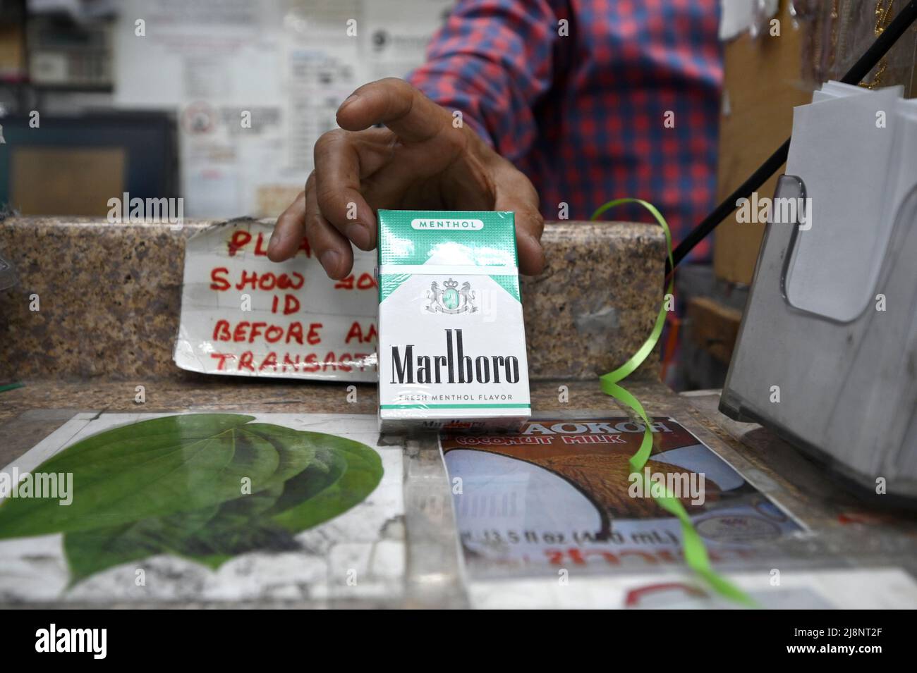 New York, USA. 17th May, 2022. A shopkeeper holds a pack of Menthol Marlboro cigarettes in the Queens borough of New York City, NY, May 17, 2022. The FDA announced it intends to ban menthol cigarettes due to higher rates of smoking-related illness and death in African-Americans communities where they are heavily advertised, as well as flavored cigars popular with younger smokers; the menthol chemical added to cigarettes reduces throat irritation associated with smoking. (Photo by Anthony Behar/Sipa USA) Credit: Sipa USA/Alamy Live News Stock Photo