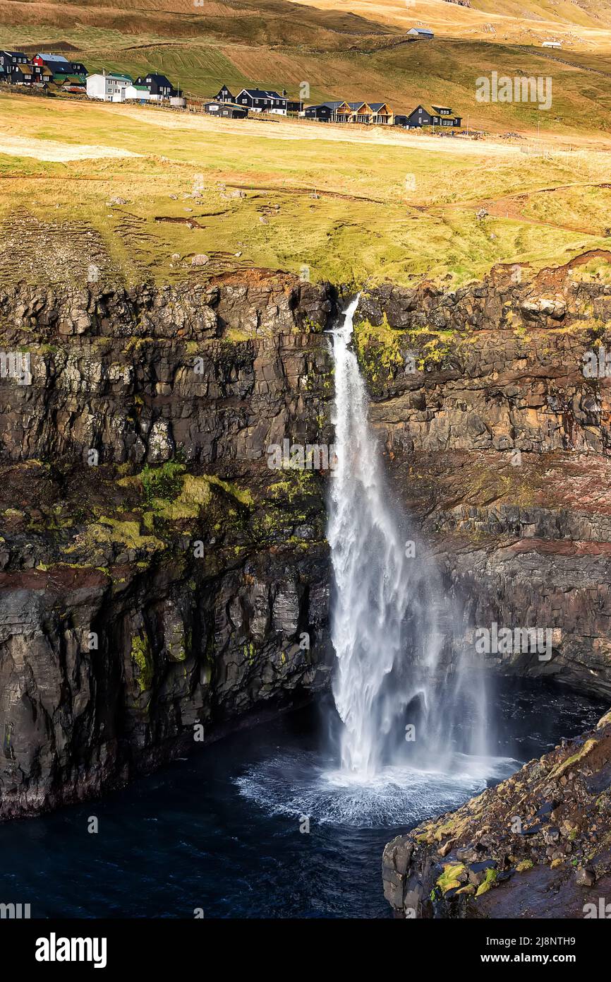Gasadalur village and amazing waterfall Mulafossur above North Atlantic ocean. Faroe Islands. Denmark. Long exposure Stock Photo