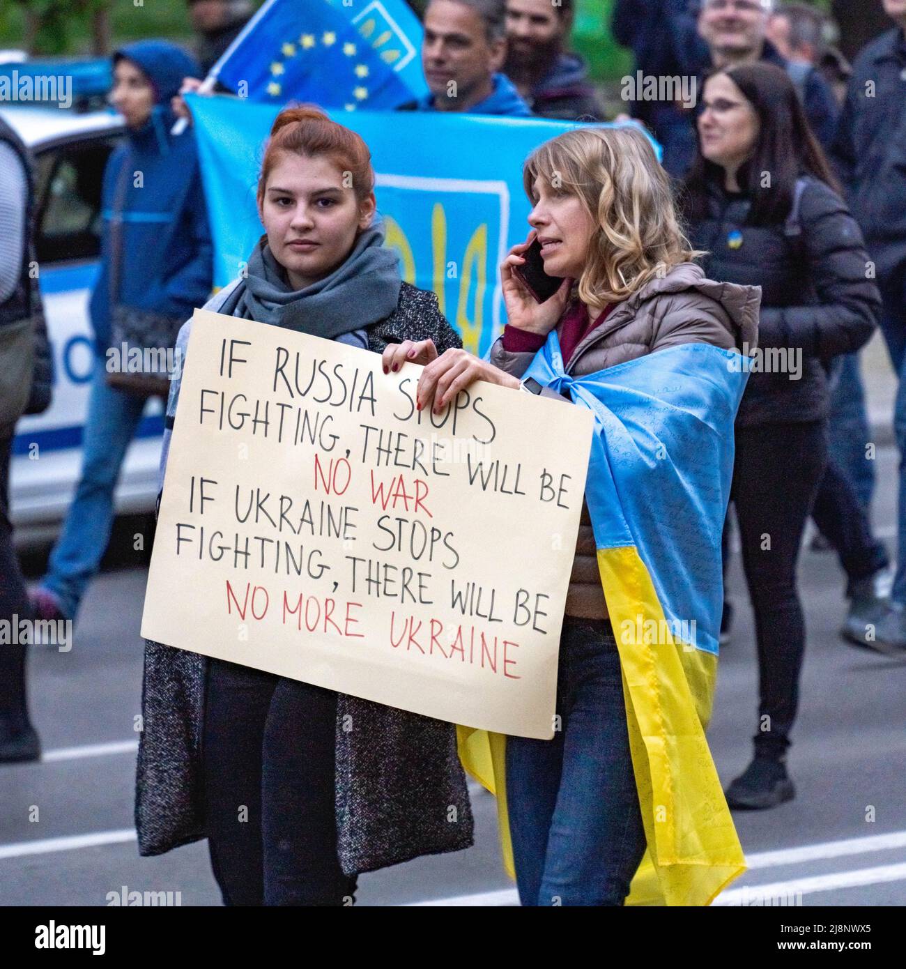 Two middle age women walk holding a banner in English together at a demonstration supporting Ukraine Stock Photo