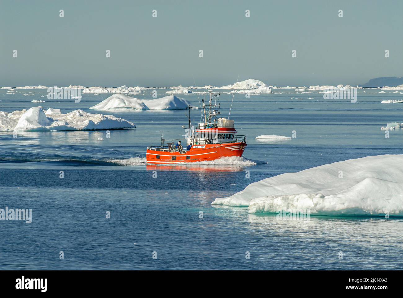 Small fishing boat among icebergs in Disko Bay, Greenland, Denmark Stock Photo
