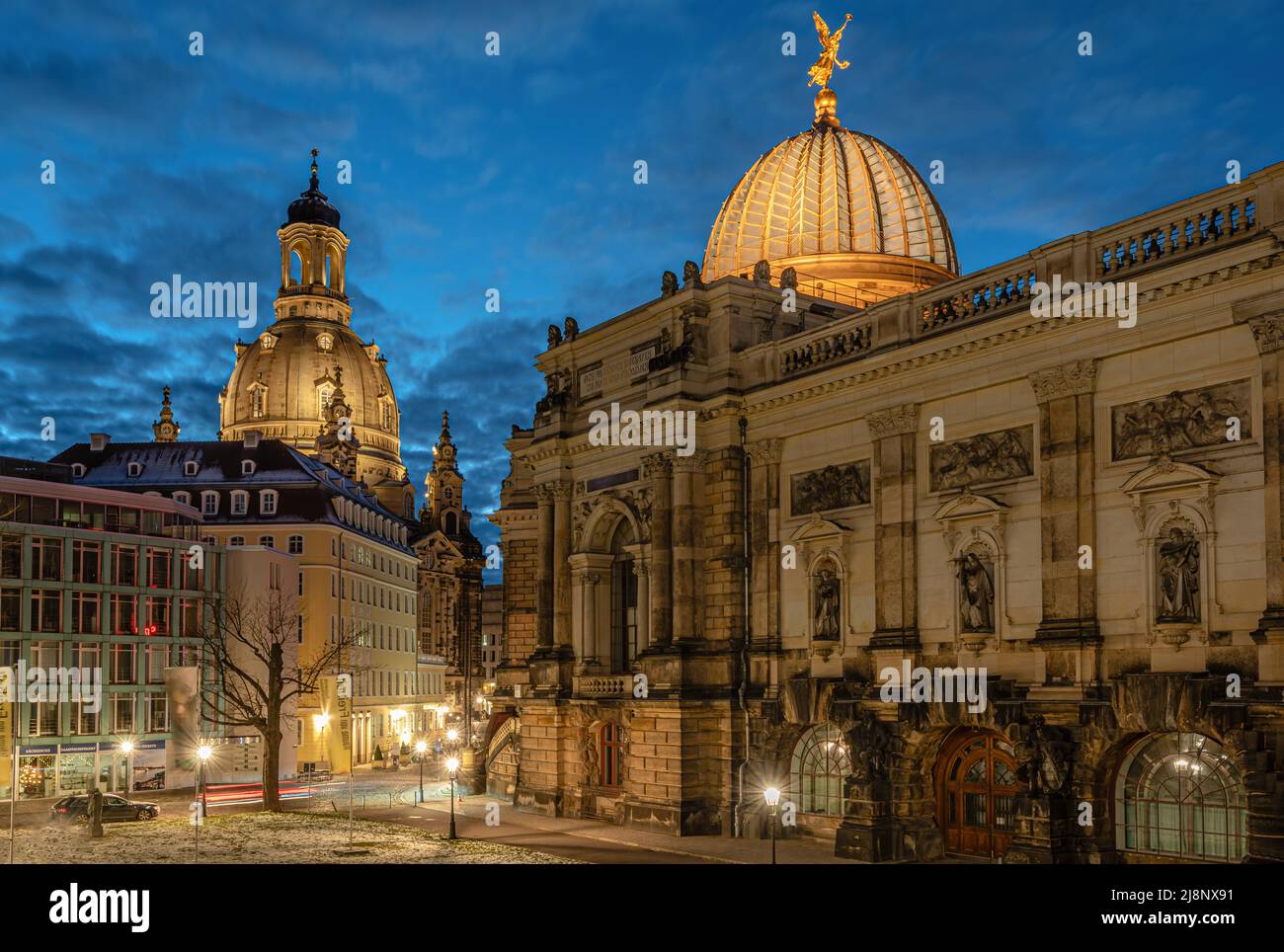 Illuminated art gallery in the Lipsius Building on Georg-Treu-Platz with the Frauenkirche Dresden at night, Saxony, Germany Stock Photo