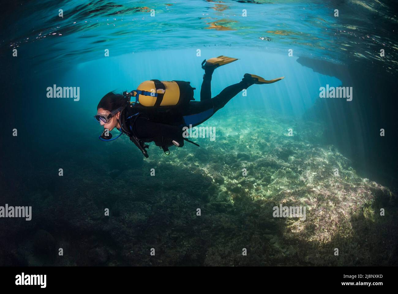 Scuba diver exploring a cave underwater Stock Photo