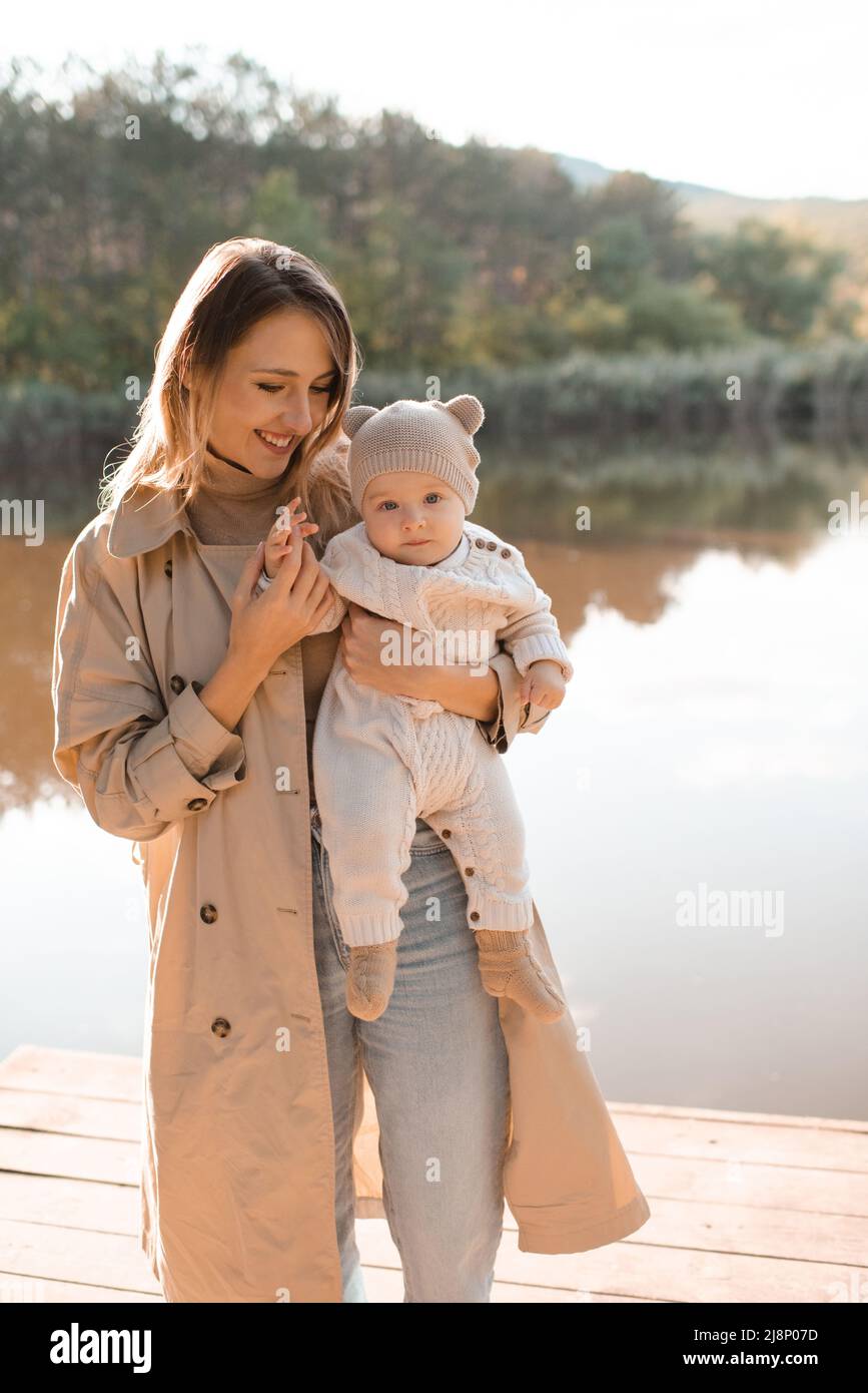 Smiling young mother playing with baby boy 1 year old wear casual clothes posing over nature
