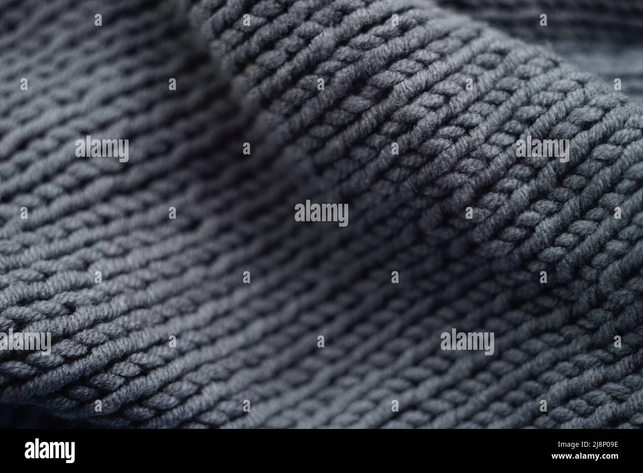 Knitted grey background, gray scarf cozy pattern. Stock Photo