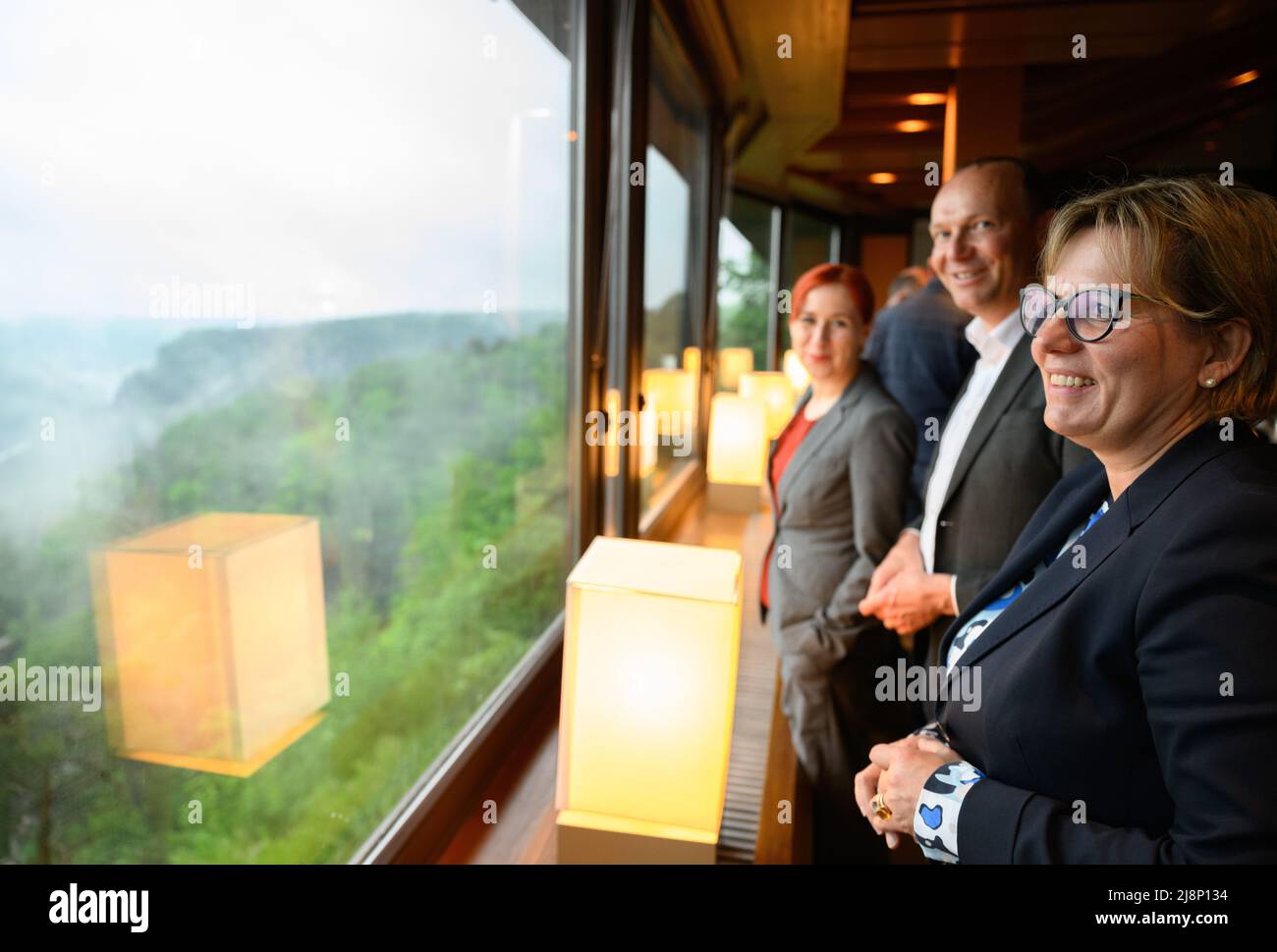 Lohmen, Germany. 17th May, 2022. Barbara Klepsch (CDU, r.), Minister for Culture and Tourism in Saxony, Wolfram Günther (Bündnis90/Die Grünen, m.), Environment Minister of Saxony, and Franziska Schubert, parliamentary group leader of the Green Party, stand at a window with a view of the Upper Elbe Valley in the conference room at the Bastei in Saxon Switzerland National Park before the start of the out-of-town cabinet meeting. Credit: Robert Michael/dpa/Alamy Live News Stock Photo