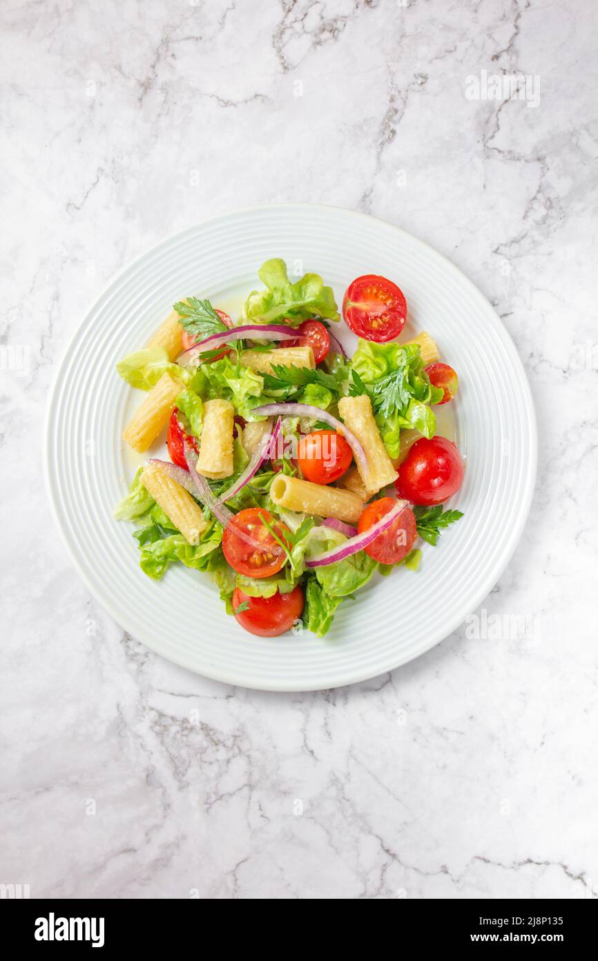 Lettuce tomato cherry salad with penne pasta Stock Photo Alamy