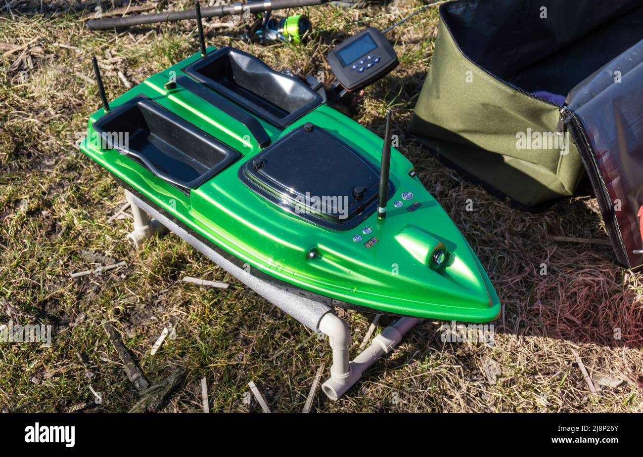 Bait Boat. A green fishing feeder with a wireless remote controller, fishfinder boat.  Stock Photo