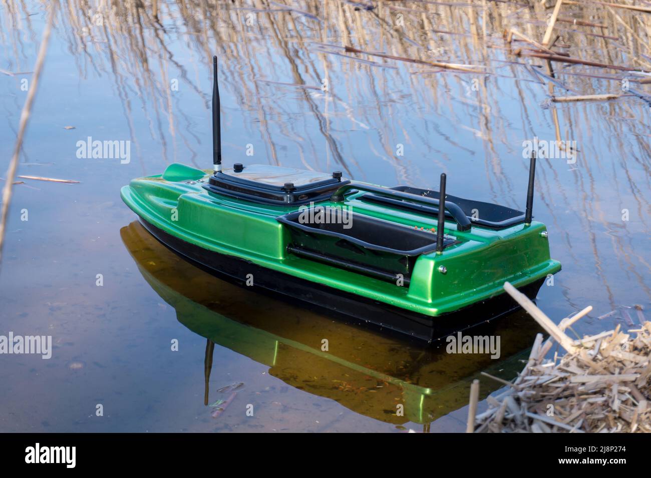 Bait Boat on water. Wireless remote control green fishing feeder, fish finder boat.  Stock Photo