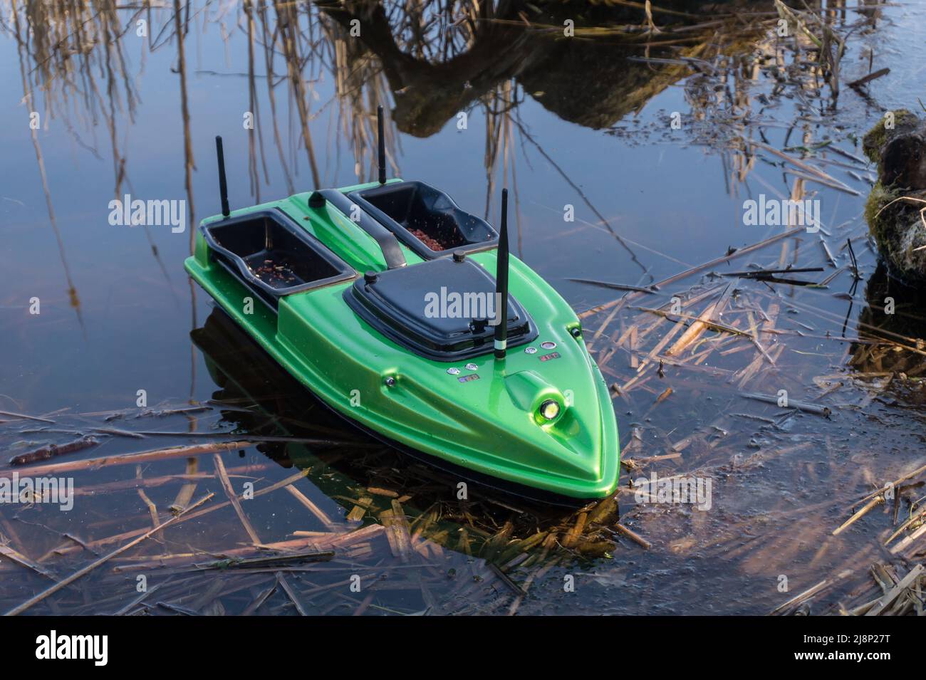 Bait Boat on water. Wireless remote control green fishing feeder, fish finder boat.  Stock Photo