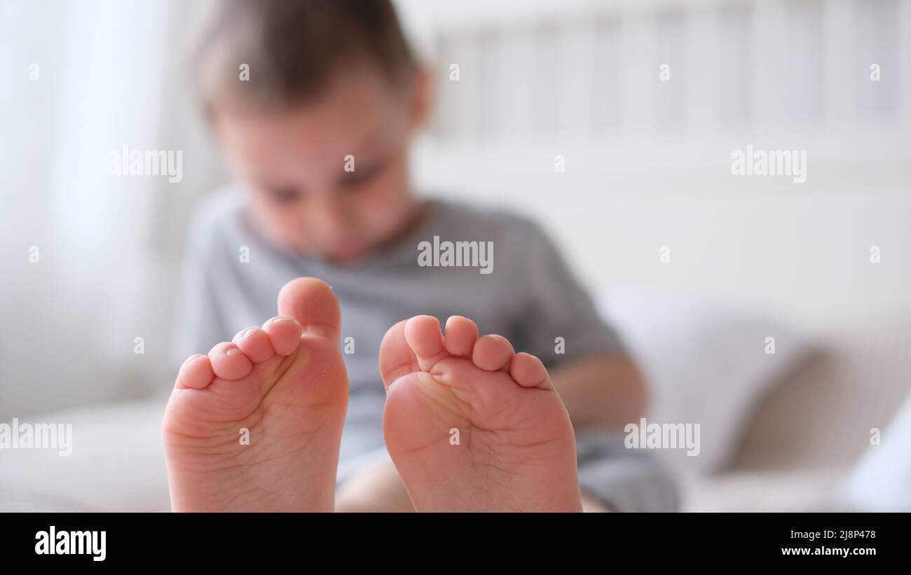 Close-up of childrens legs with feet forward Stock Photo