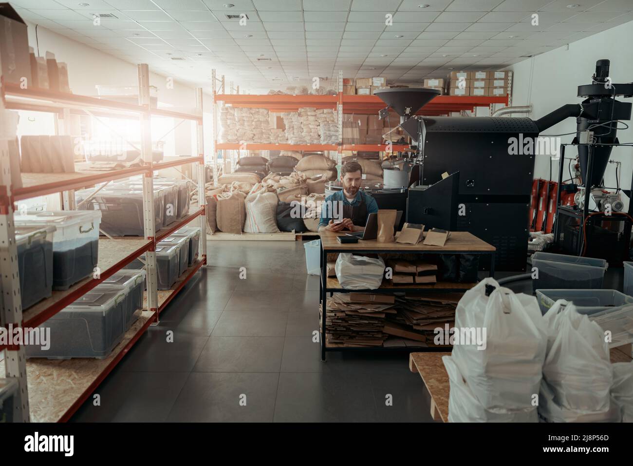 Business owner of small coffee roasting factory working on his